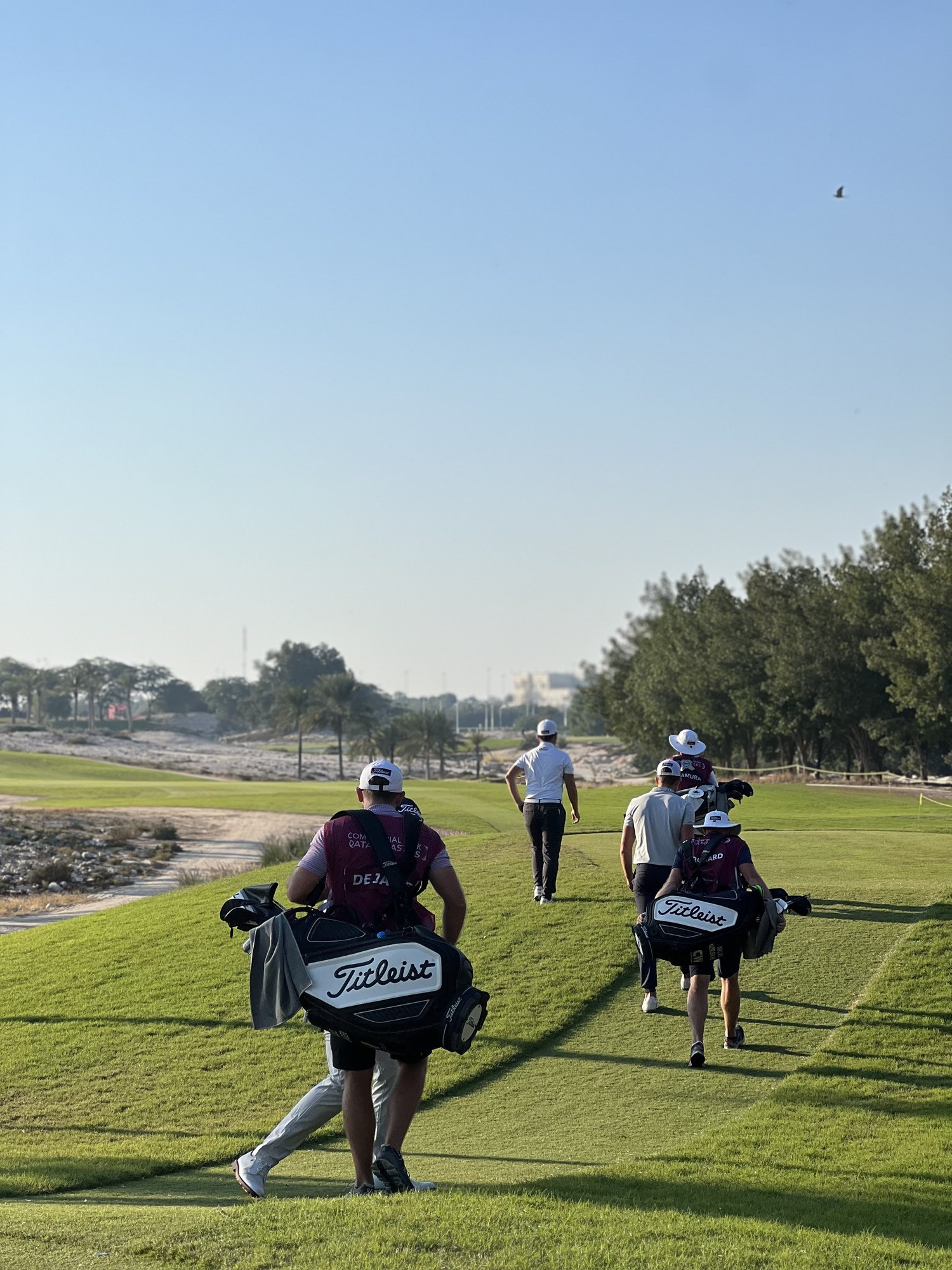 Caddies walking the fairway, Doha Golf Club, Qatar