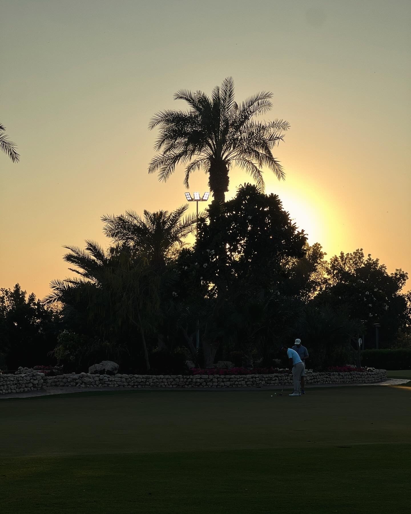 A golf bag against the clubhouse at sunset, Doha Golf Club, Qatar